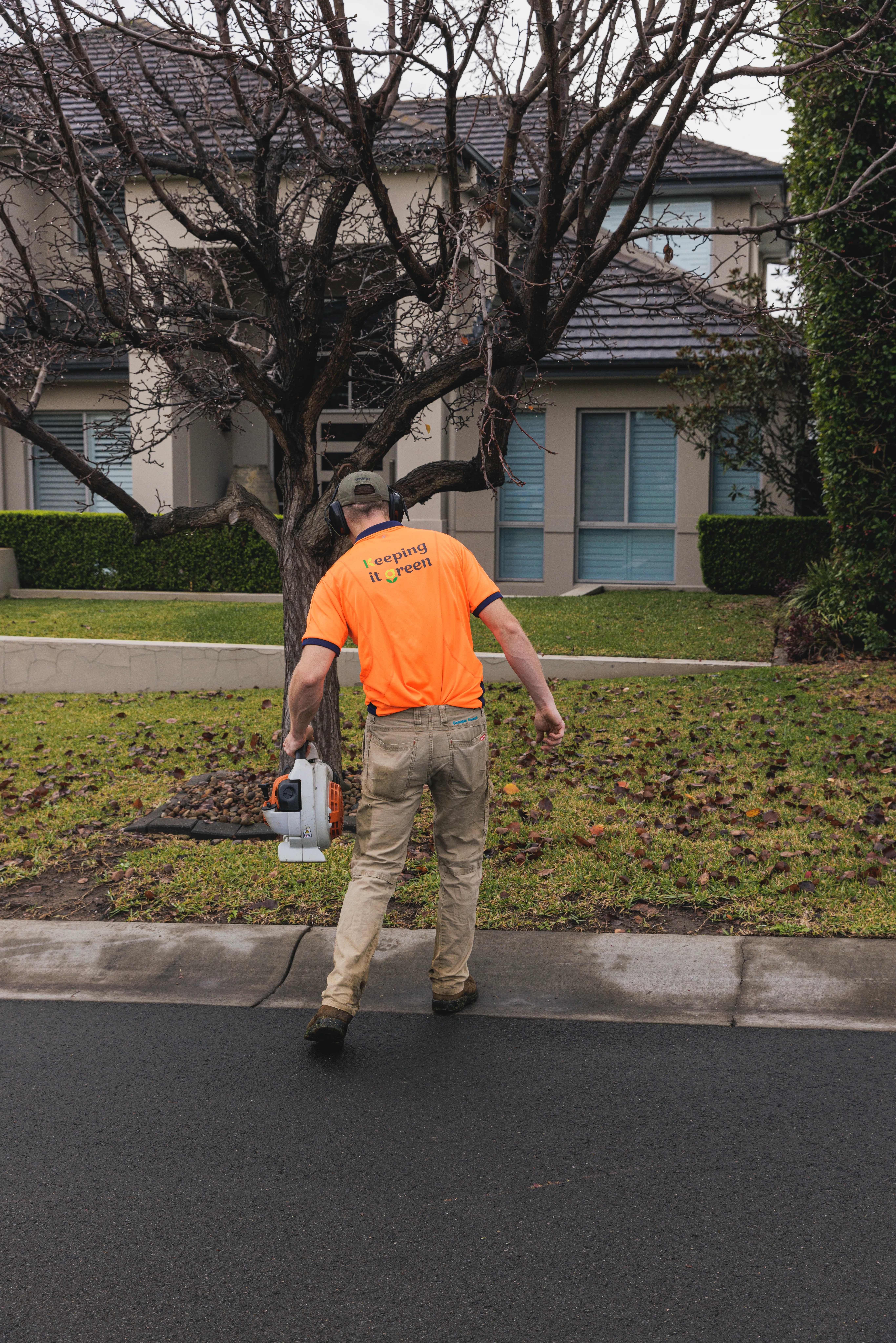 Blowing clippings off a driveway after whipper snipping in Camden