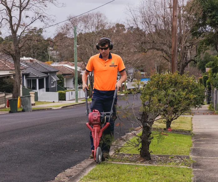 Keeping It Green team member edging a lawn along a street in Harrington Park NSW