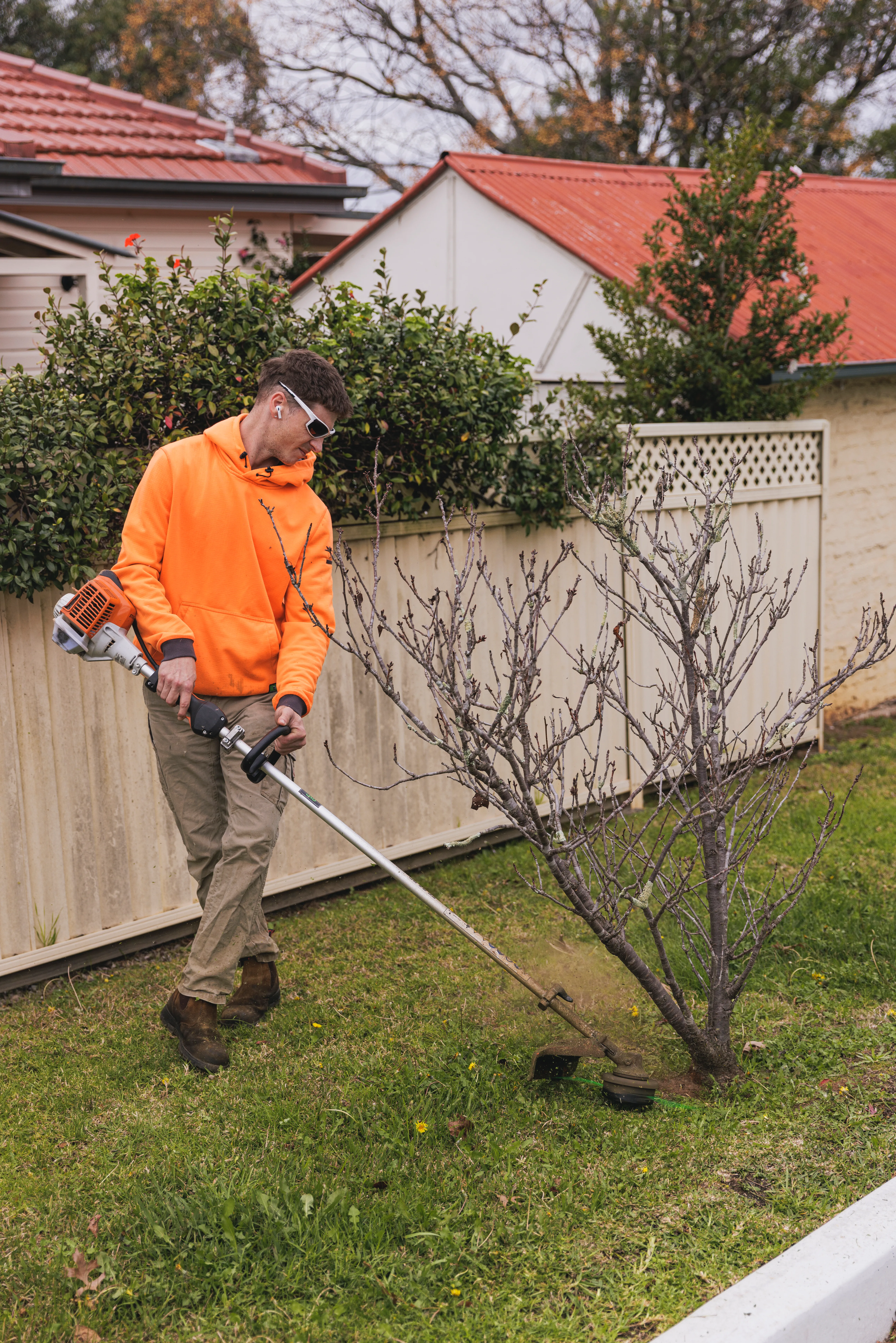 Whipper snipping along a fence line on an acreage property