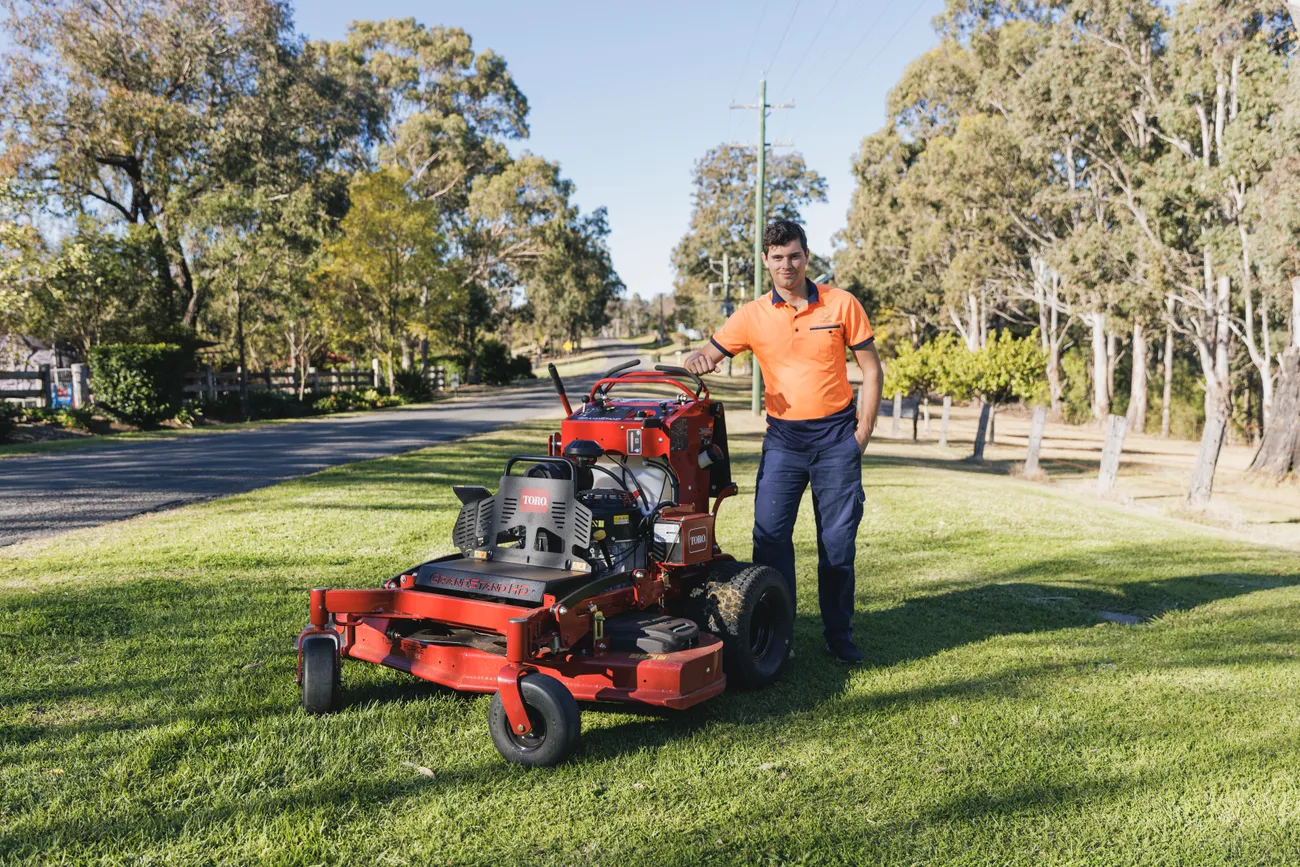 Jack from Keeping It Green standing with lawn mowing equipment in Camden NSW