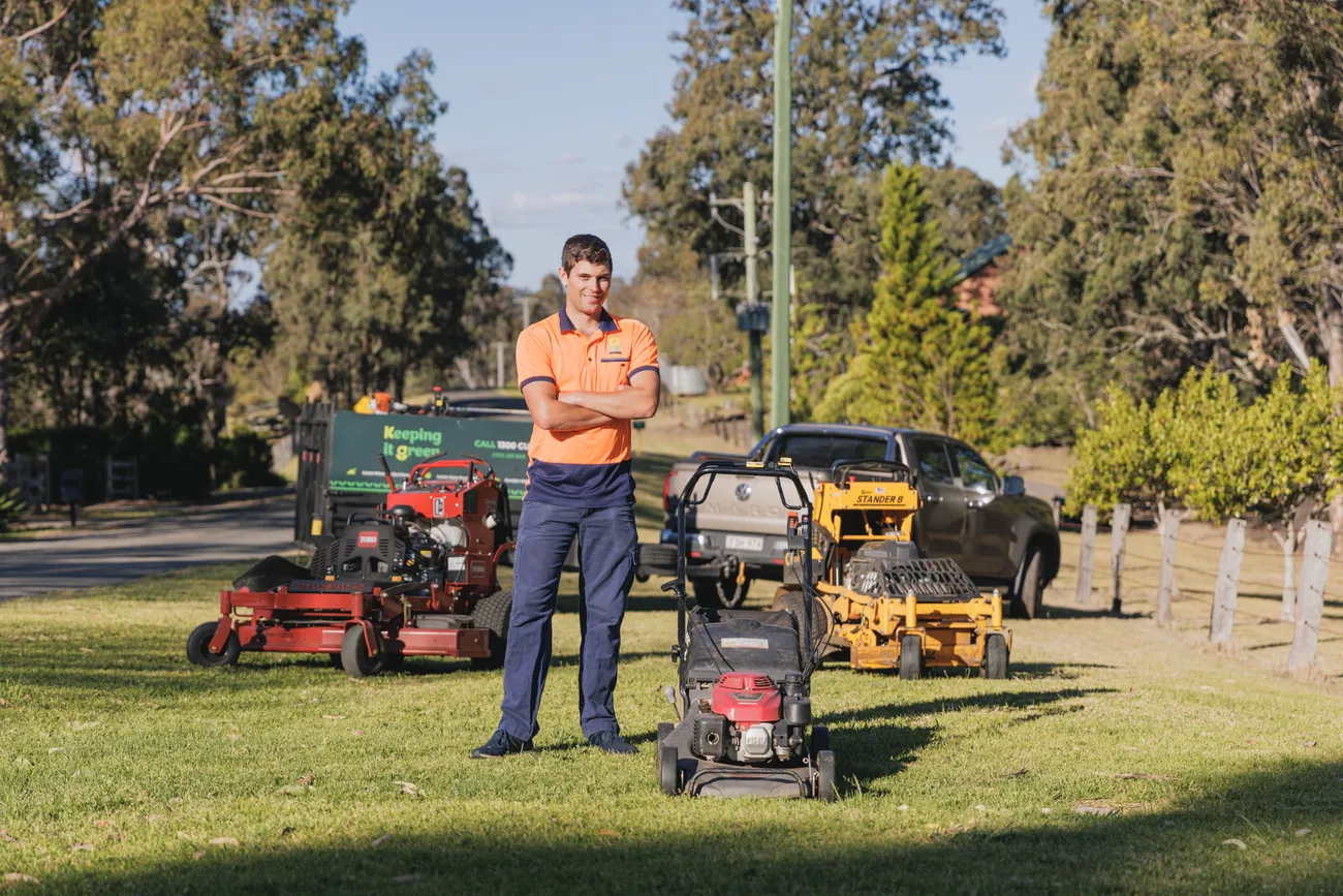 Jack from Keeping It Green standing with lawn mowing equipment in Camden NSW