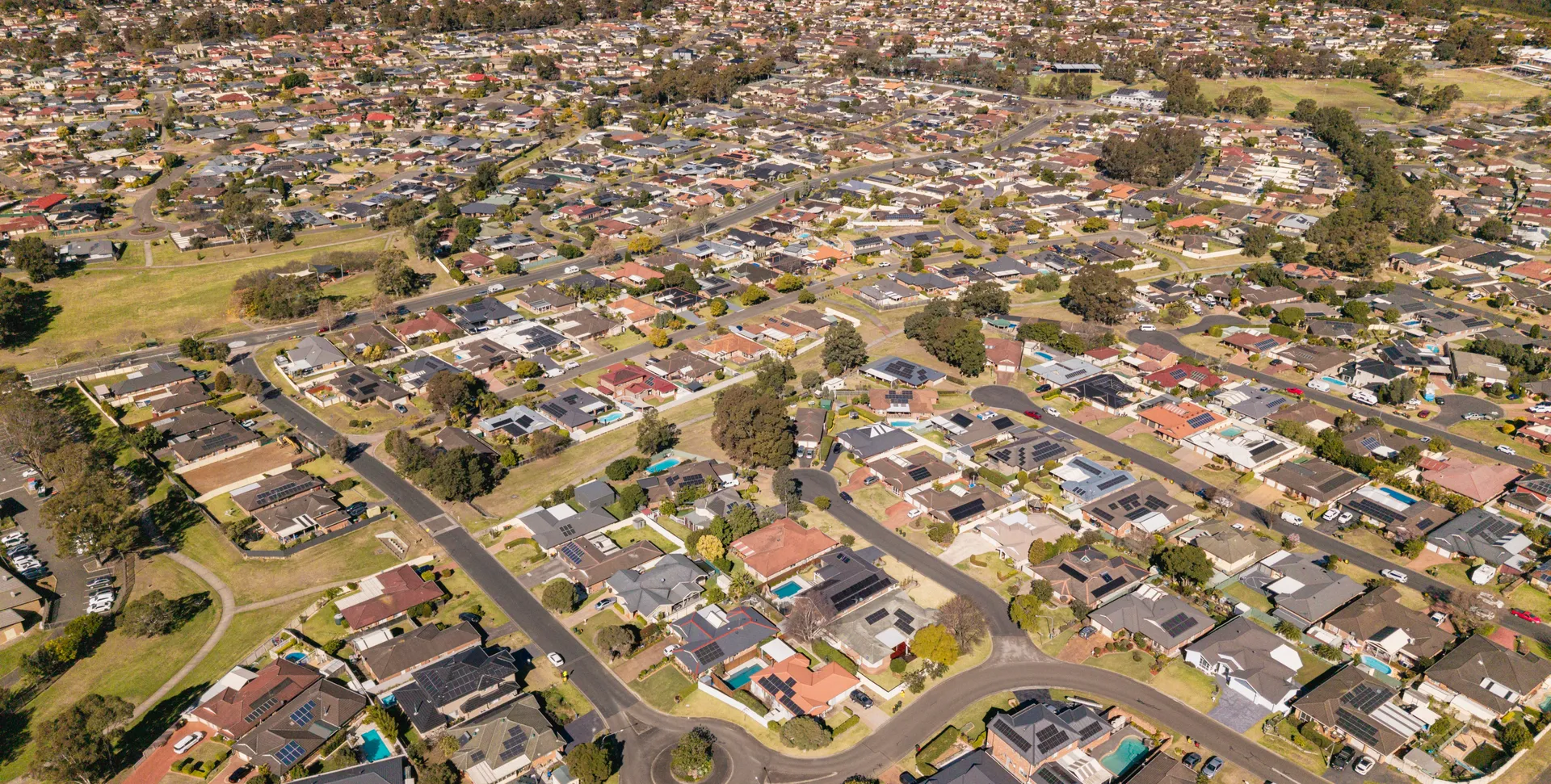 Aerial view of Narellan Vale showing established family homes, backyard pools and local sports fields