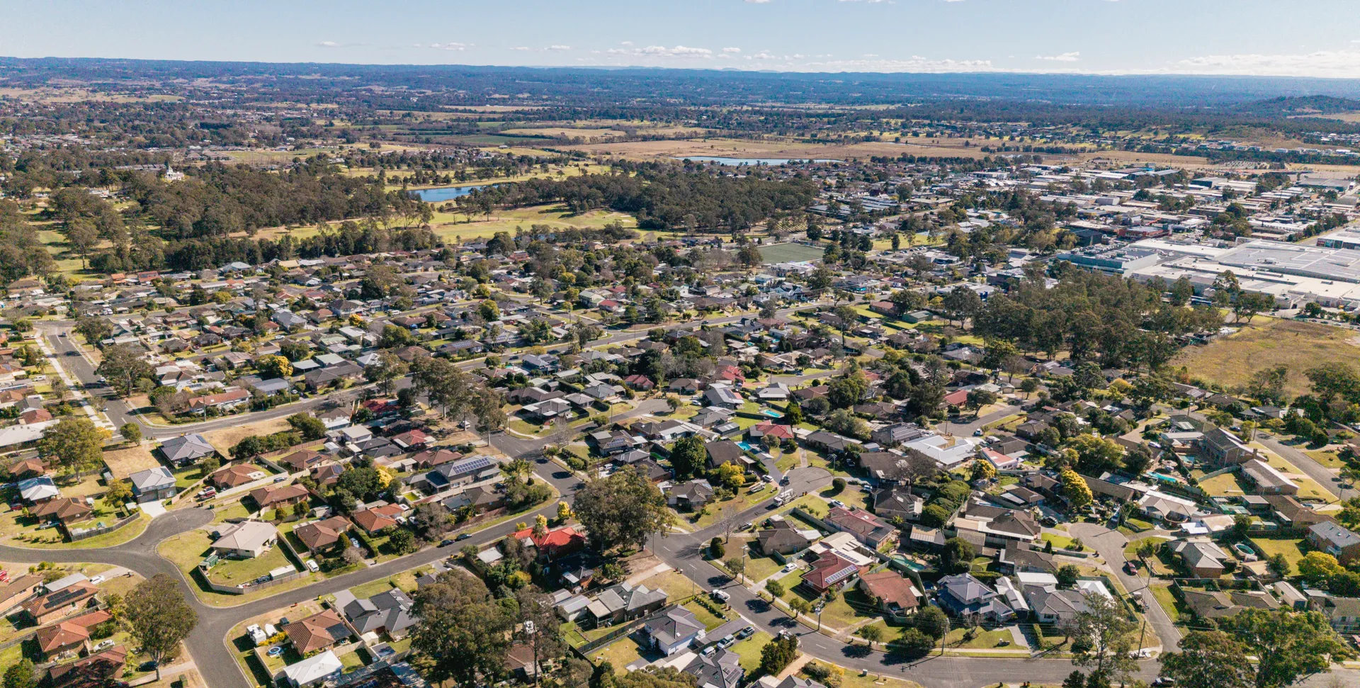 Aerial view of Narellan showing established homes on large tree-lined blocks with Narellan Town Centre beyond